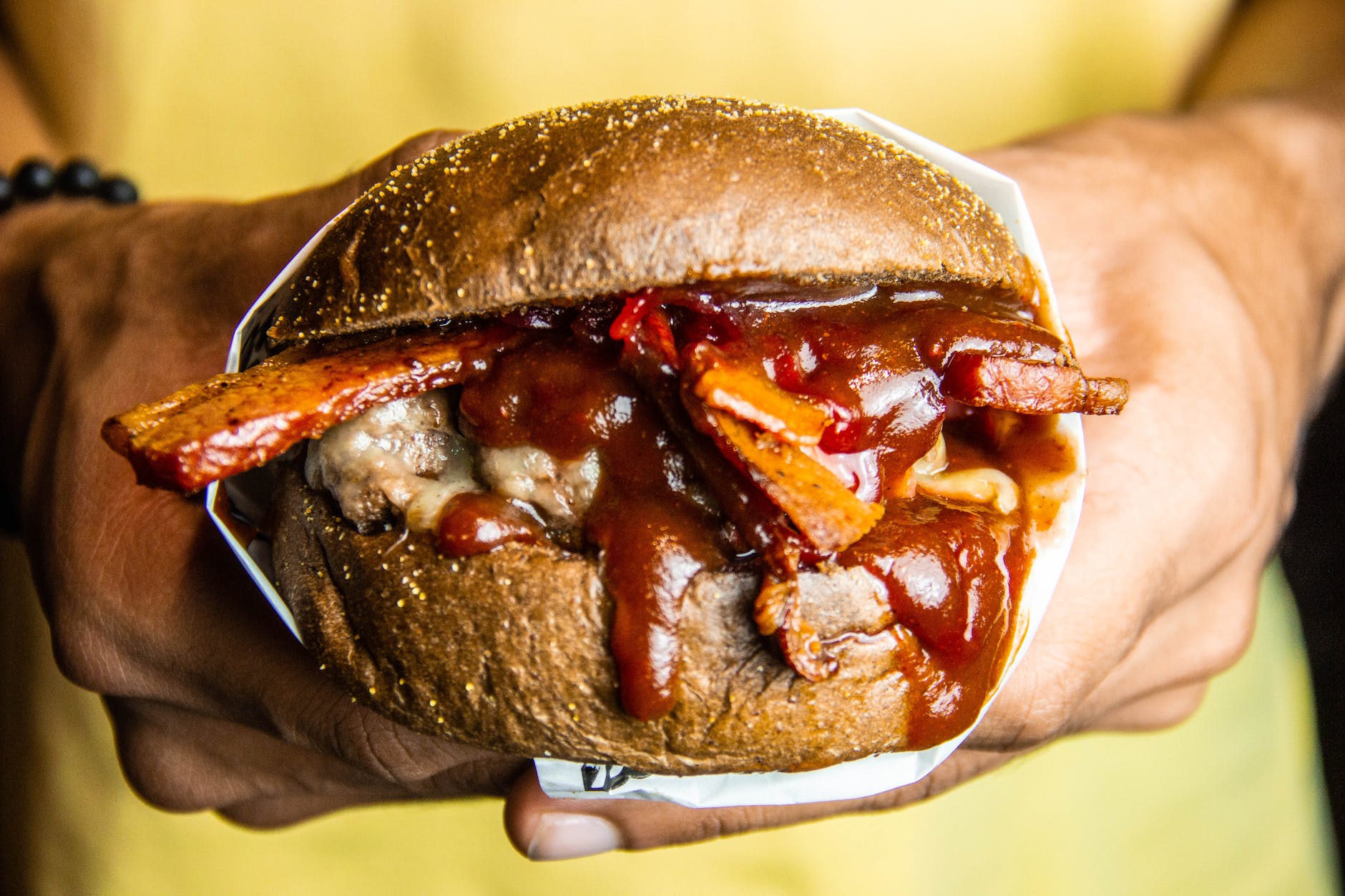 person holding grilled cheese burger