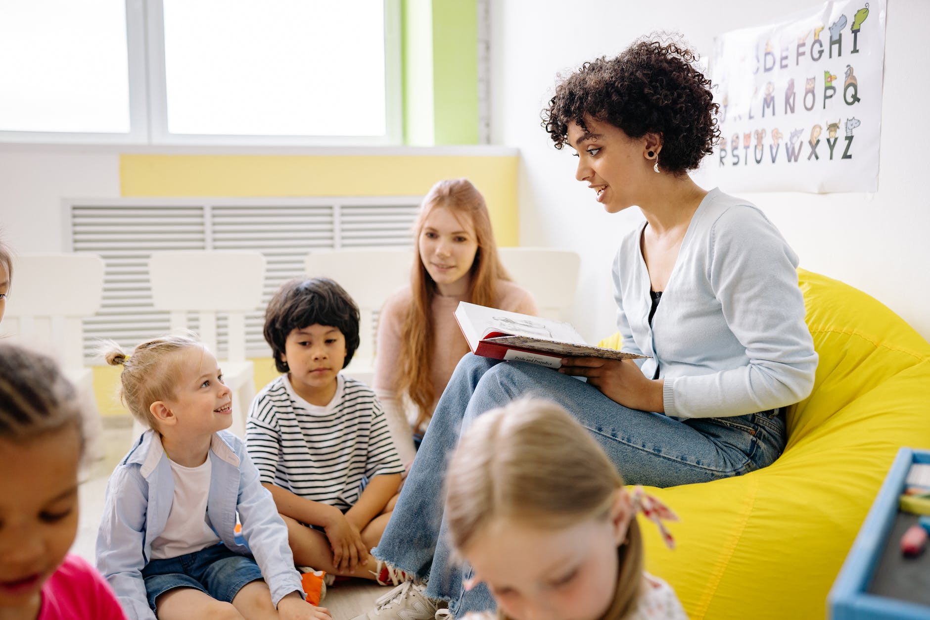 woman reading a book to the children